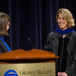 A member of faculty smiles as she receives an award